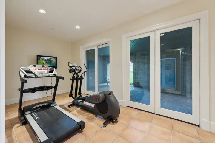 Recessed lighting illuminates a versatile space with neutral wall tones and tile flooring