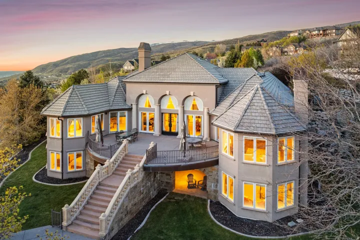 Stately multi-level residence with a stone retaining wall and expansive outdoor deck