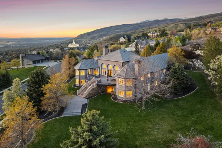 Stone exterior with multiple bay windows, a prominent deck, and a multi-level staircase