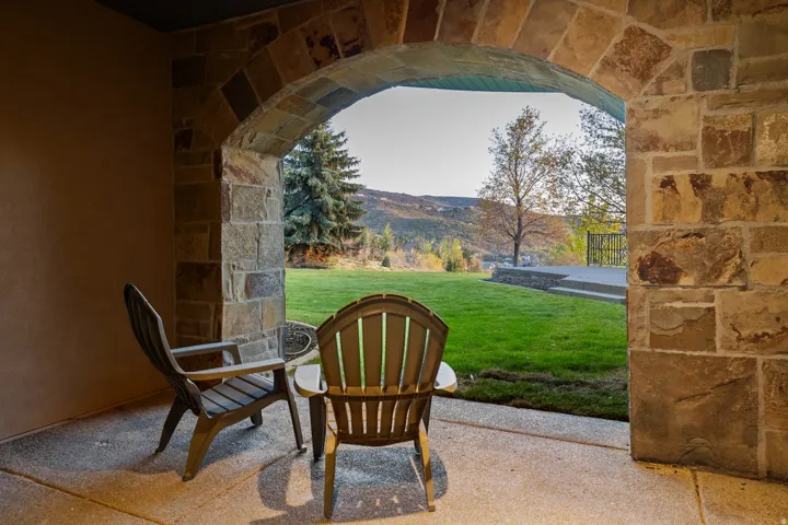 Stone archway leading to an outdoor patio with a concrete surface