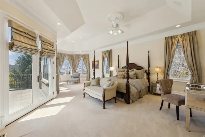 Tray ceiling with decorative medallion, recessed lighting, crown molding, double French doors, and multiple windows