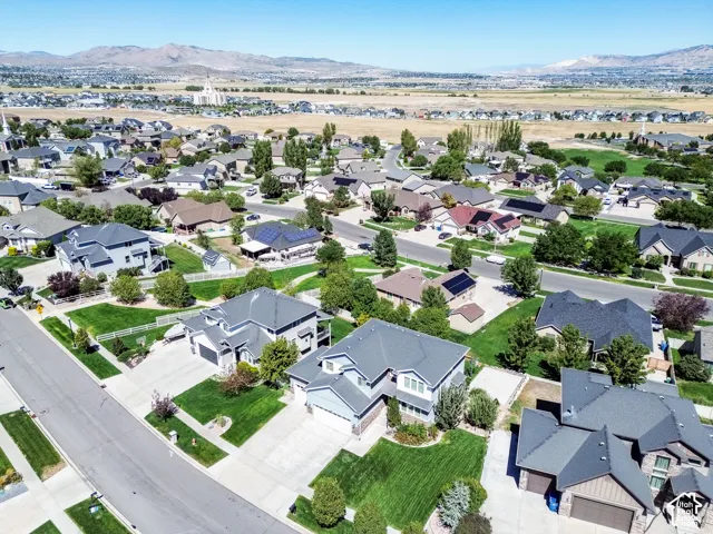 Residential neighborhood with mature trees, paved streets, and a mountainous backdrop