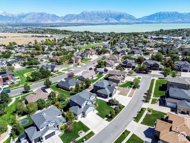 Residential neighborhood with mature landscaping, paved streets, and a prominent mountain range backdrop
