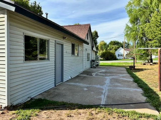 Concrete patio with direct exterior access, siding exterior, and shingle roofing