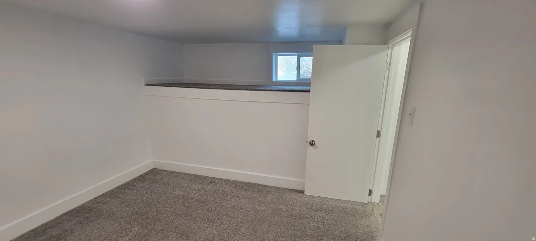 Wall-to-wall carpeting, crisp white walls, and a recessed ceiling light fixture