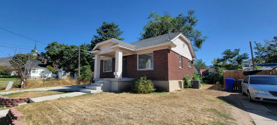 Brick exterior with gabled roof, covered porch, and concrete walkway