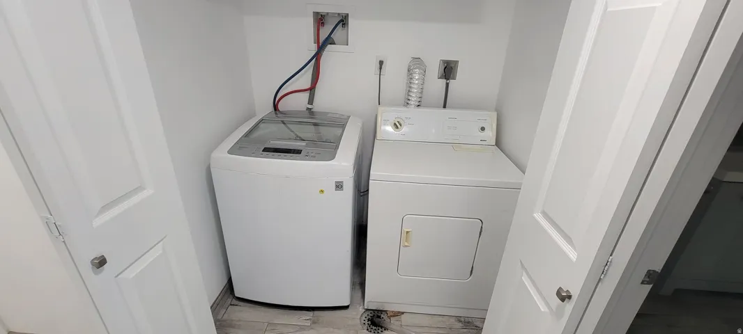 Compact laundry area featuring white walls and light-toned flooring