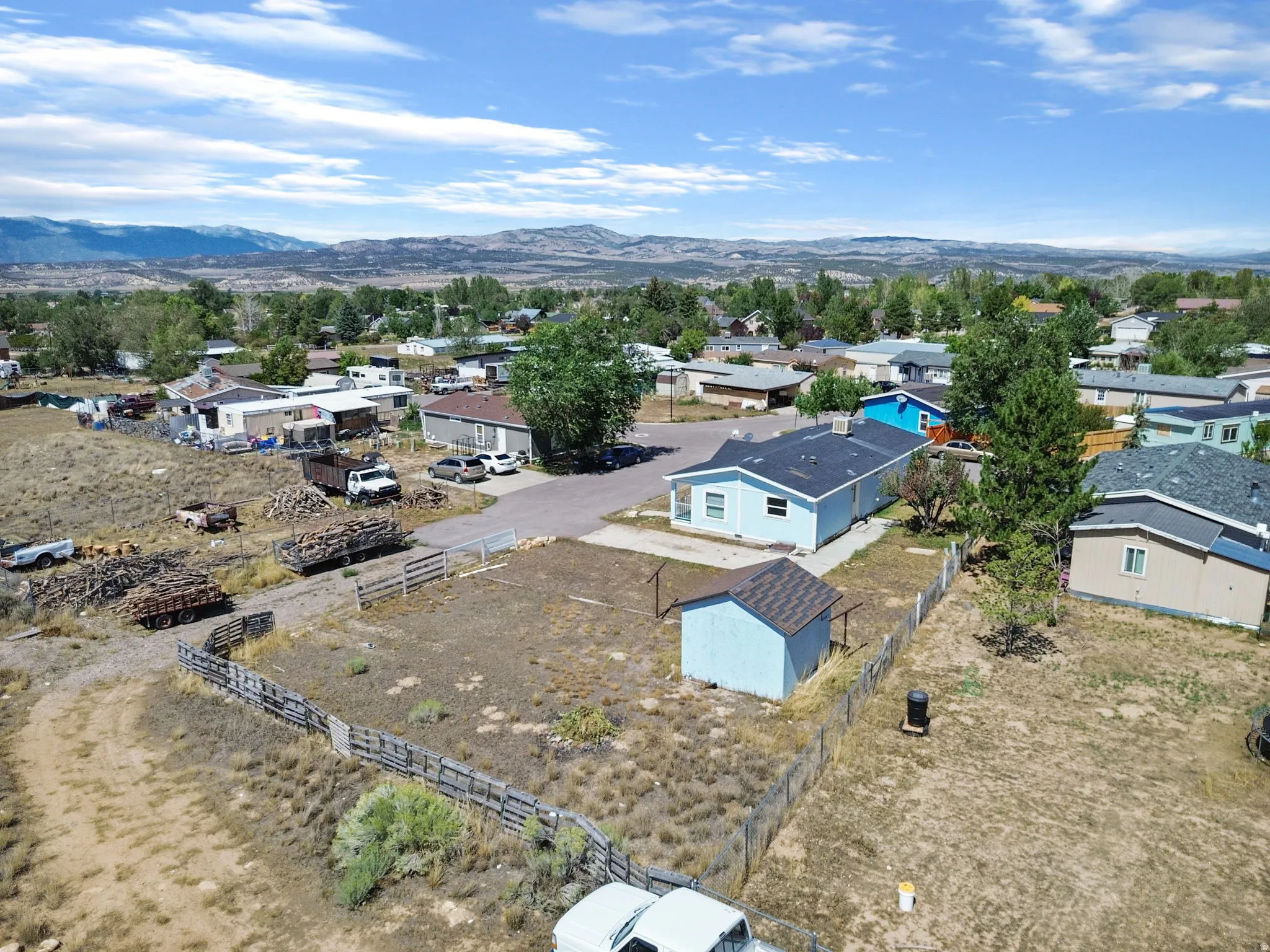 Expansive property featuring a detached shed, partial fencing, and a mountain backdrop