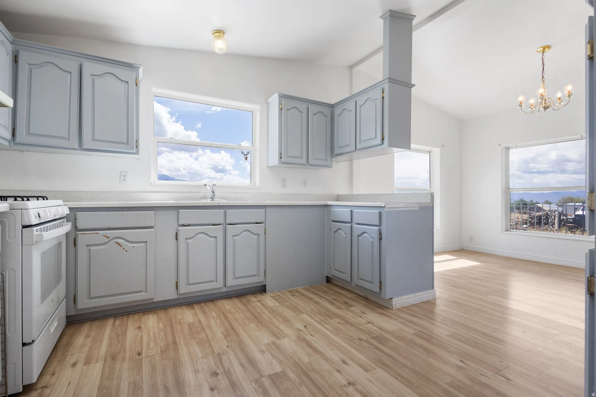 Kitchen featuring blue-finish cabinetry, white countertops, a built-in range, and wood-finish flooring