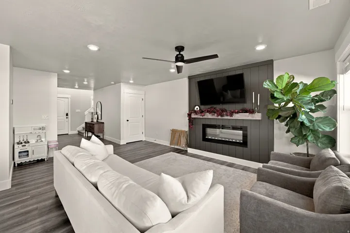 Living area featuring wood-finish flooring, recessed lighting, and a ceiling fan