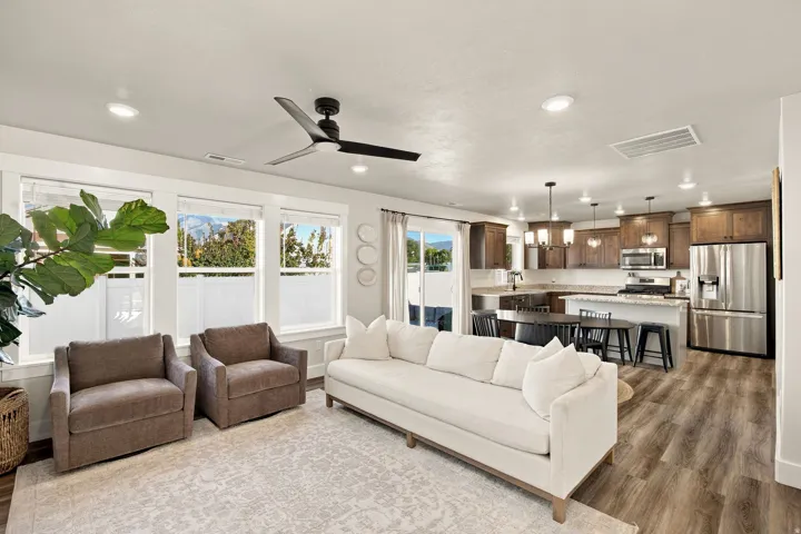Recessed ceiling lighting, wood-finish flooring, built-in kitchen cabinetry, stainless steel appliances, and a ceiling fan