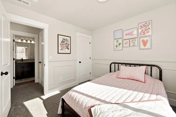 Light-colored walls featuring wainscoting, carpeted flooring, and a ceiling-mounted light fixture