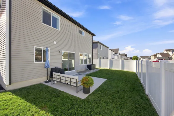 Expansive green lawn, durable vinyl fencing, and a concrete patio