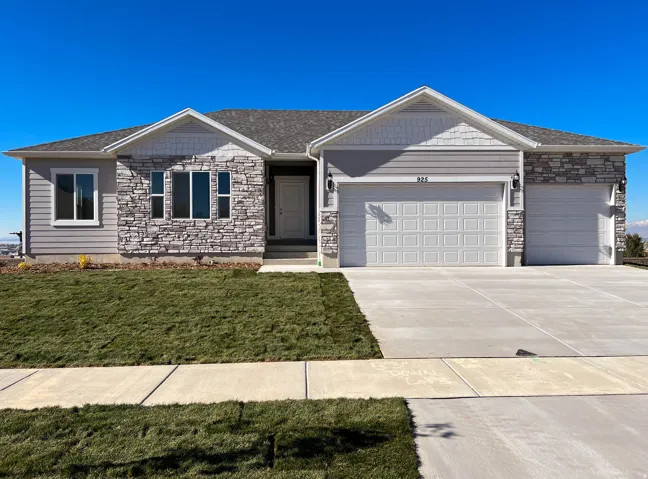 Exterior featuring stone and siding accents, a two-car garage, an additional single-car garage, and a concrete driveway