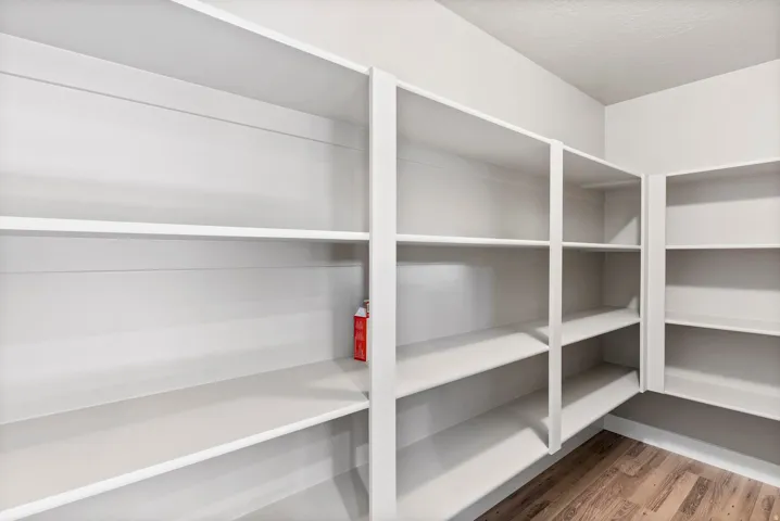 Built-in shelving with multiple levels, corner shelving unit, and wood-finish flooring