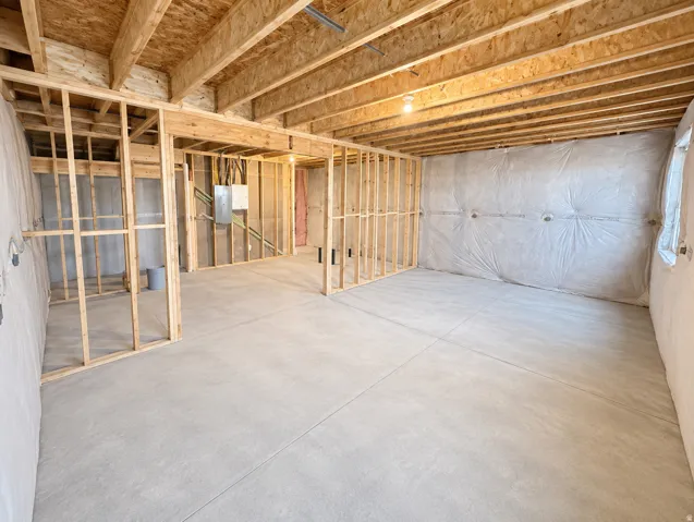 Unfinished basement offering structural framing, exposed ceiling joists, and concrete flooring
