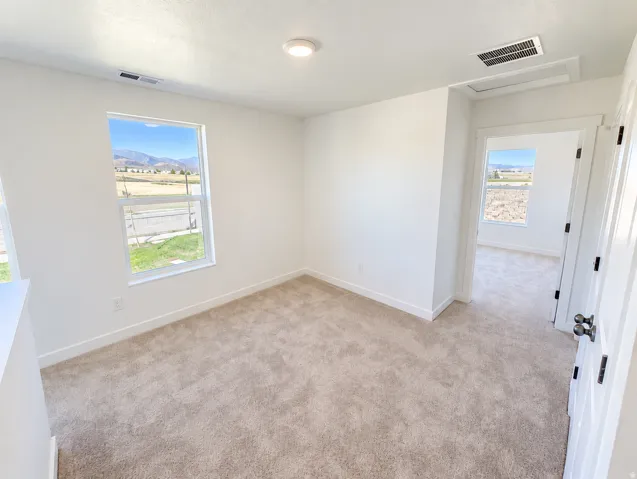 Neutral tone carpeting, white walls, and a recessed ceiling light