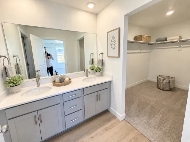 Dual vanity with stone-finish countertop, undermount sinks, and wood-finish flooring
