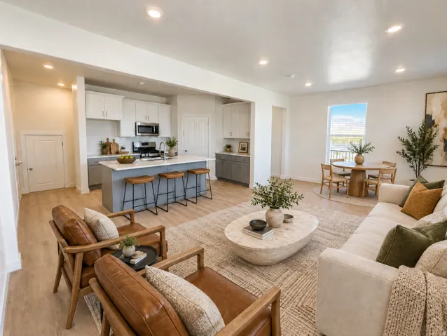 Open-concept living area with wood-finish flooring, recessed lighting, and a kitchen island with seating