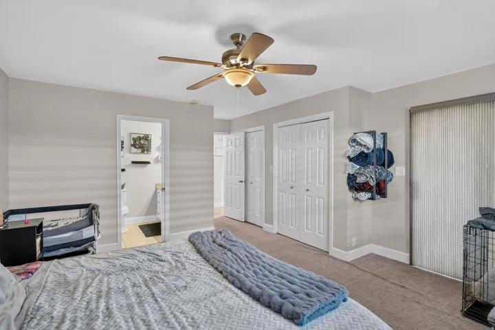 Ceiling fan fixture, neutral wall color, carpeted flooring, white paneled doors, and vertical window blinds