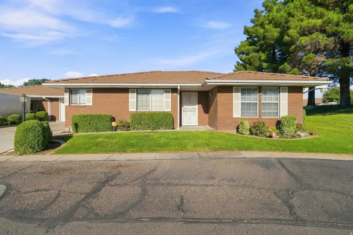 Brick exterior with white window shutters and a brown shingle roof