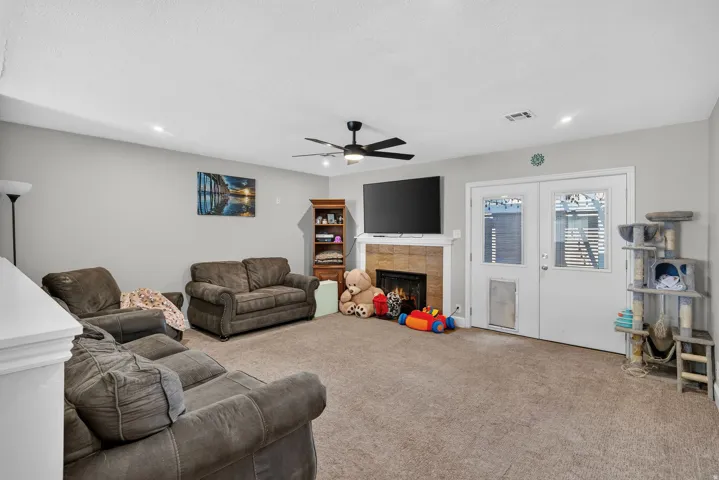 Recessed lighting, ceiling fan, and a fireplace with a stone surround