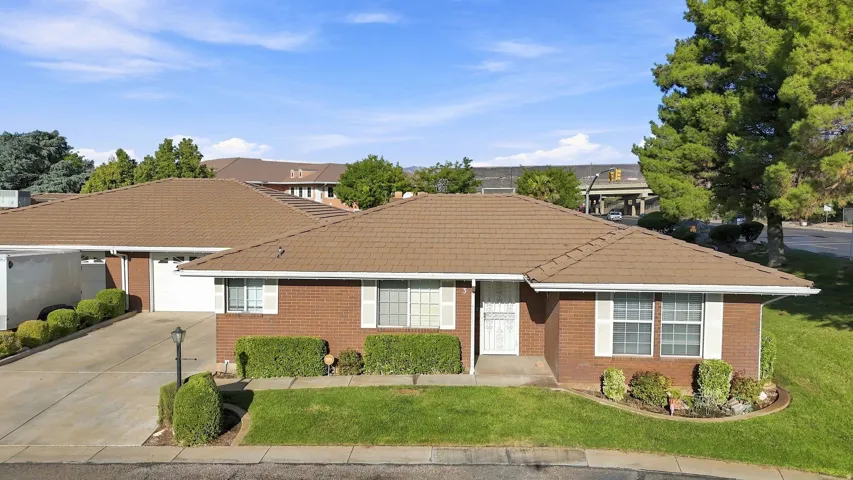 Brick exterior with white window shutters and a brown tile roof