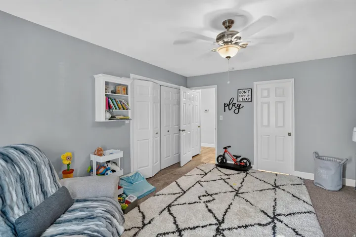 Room featuring a ceiling fan with integrated lighting, white bi-fold closet doors, and white paneled doors