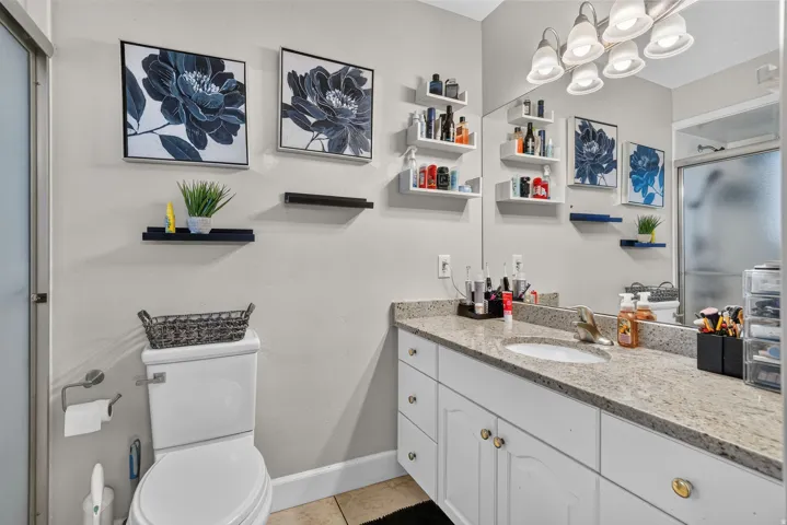 Vanity with a granite countertop, undermount sink, and white cabinetry