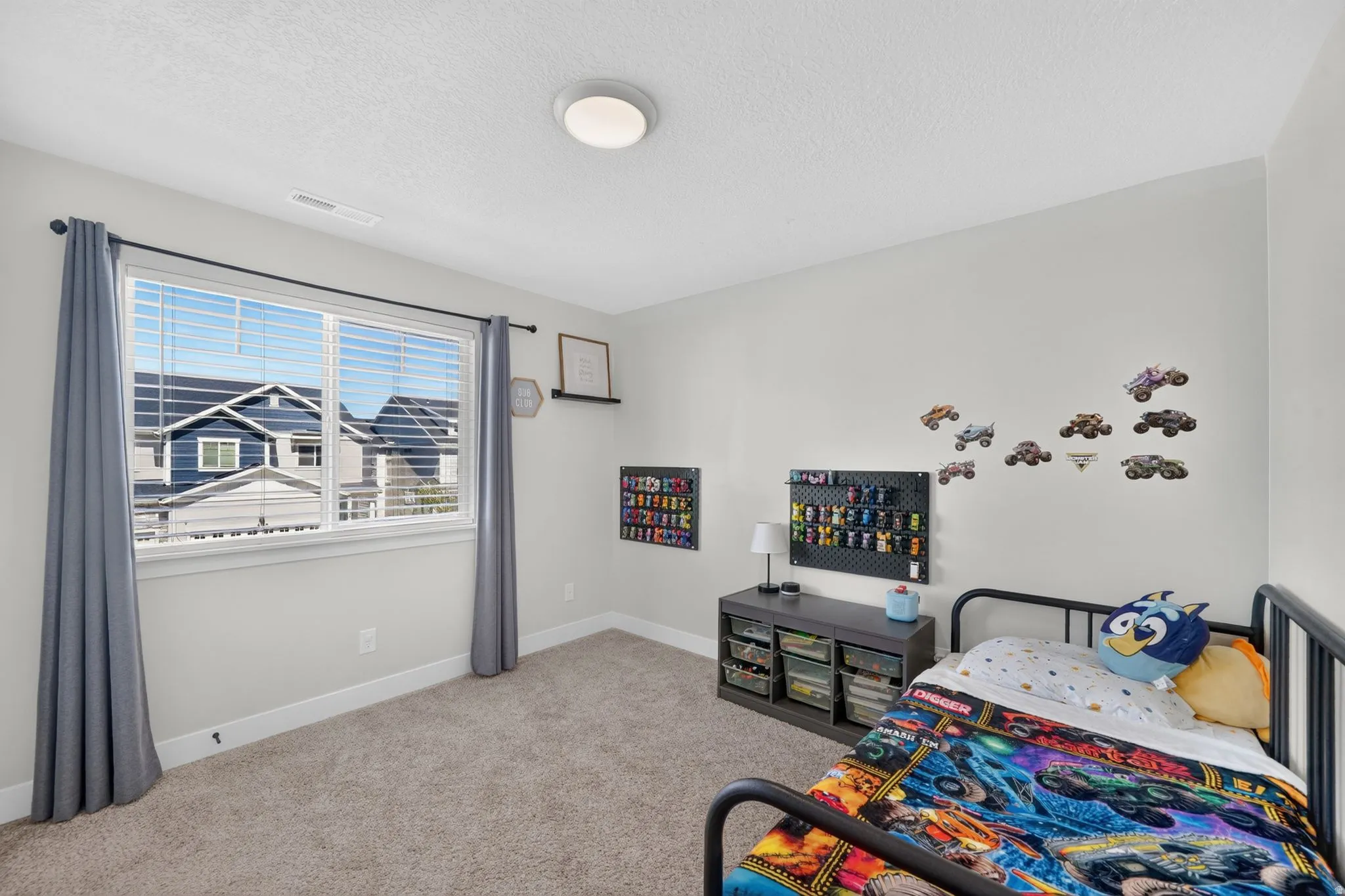 Wall-to-wall carpet flooring, light neutral paint, and a large window with blinds