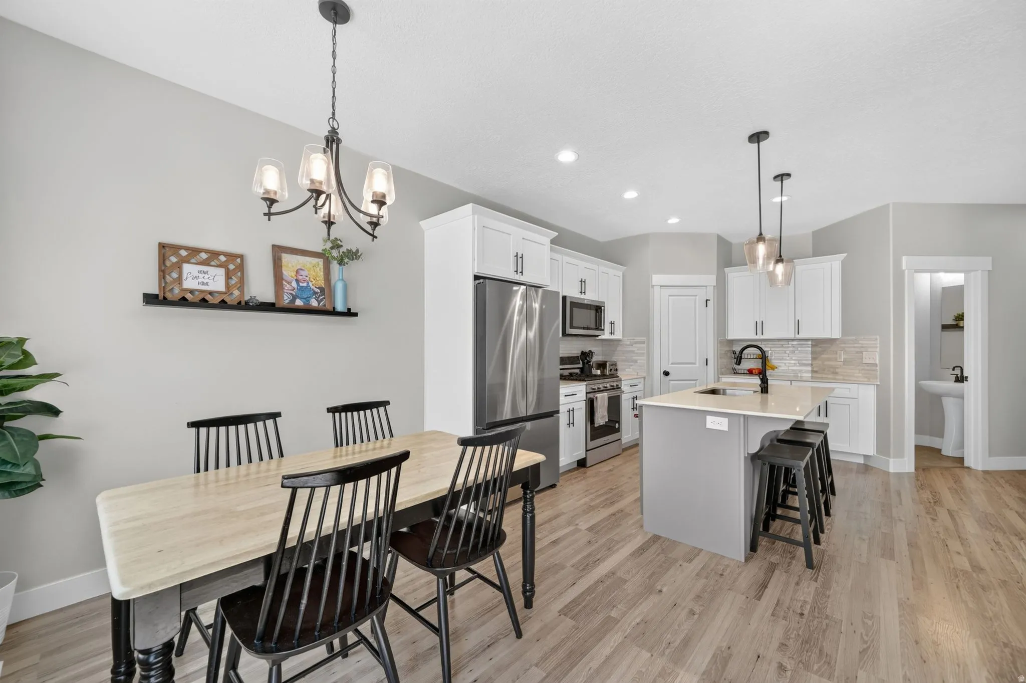 Open-concept kitchen and dining area featuring light wood-finish flooring