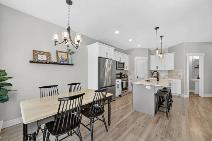 Open-concept kitchen and dining area featuring light wood-finish flooring