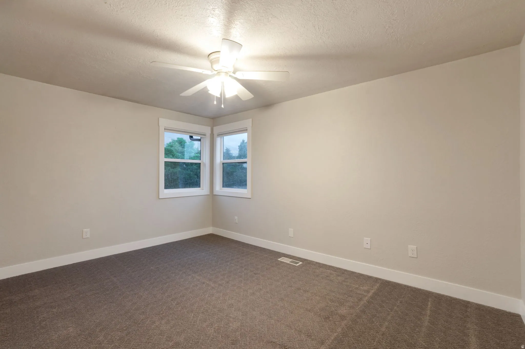 Neutral wall finishes, recessed windows, textured carpeting, and a ceiling fan with integrated lighting