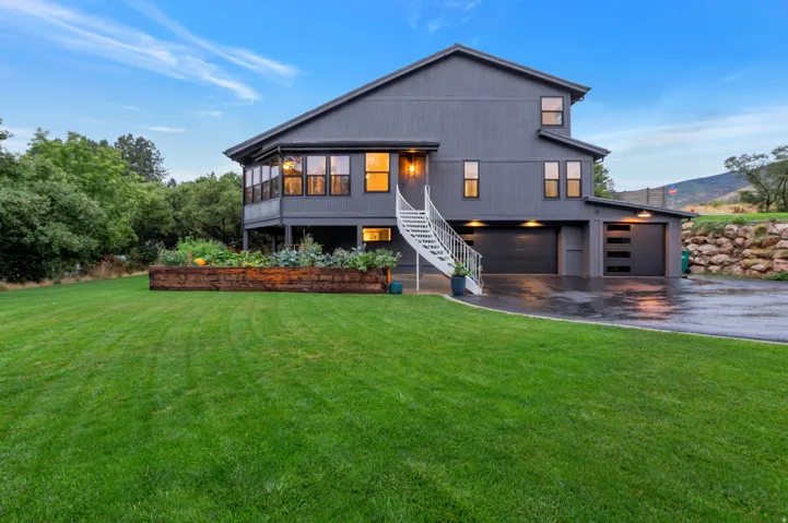 Modern gray exterior featuring, multiple garages and large yard.
