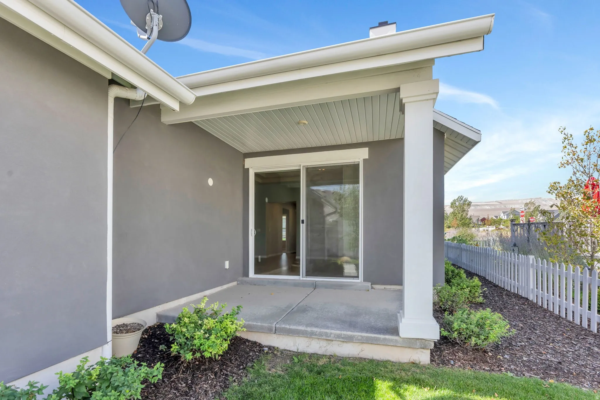 Concrete patio with a covered overhang and a sliding glass door