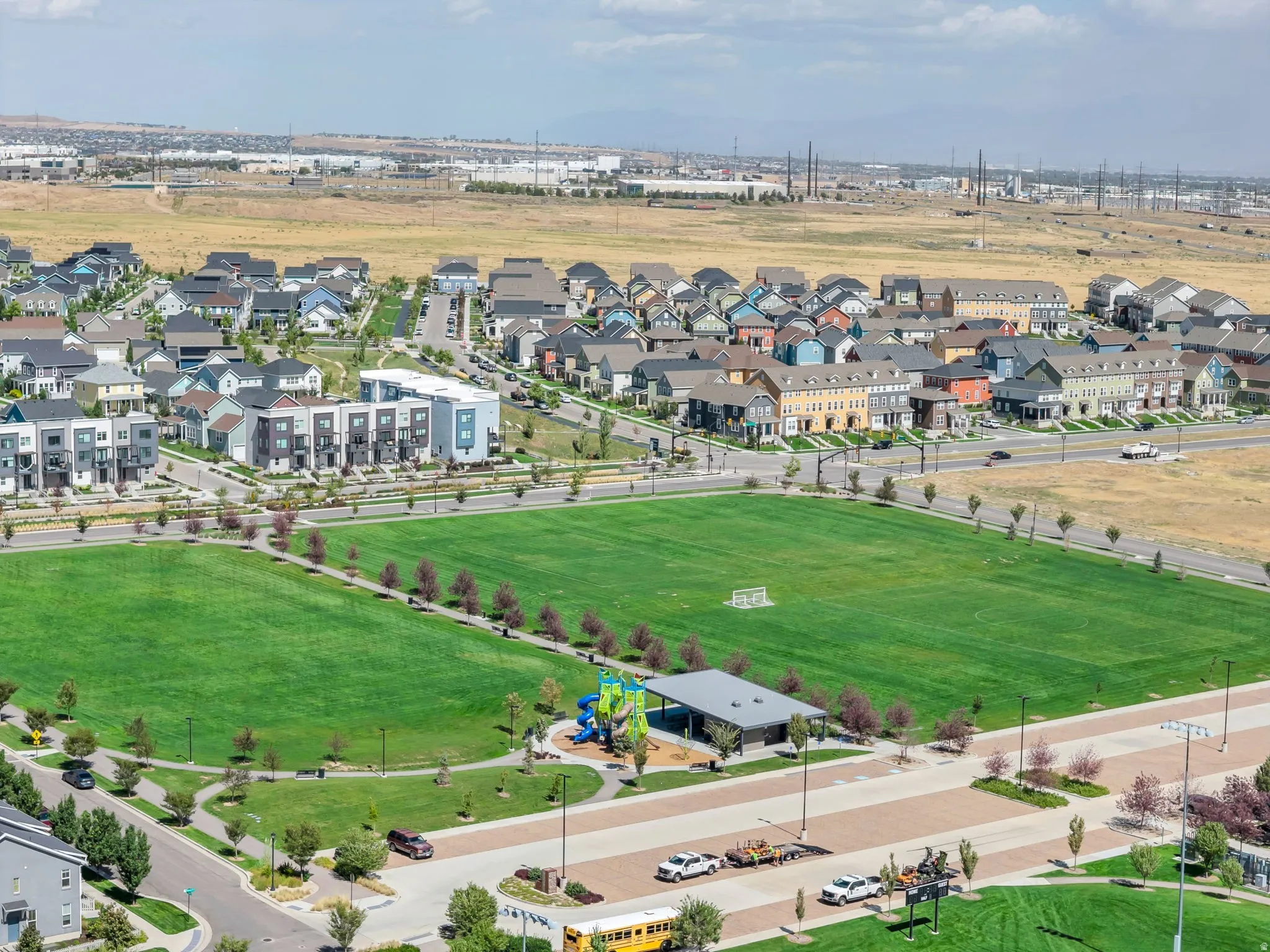 Extensive green space with a playing field, children's play structure, and covered seating area