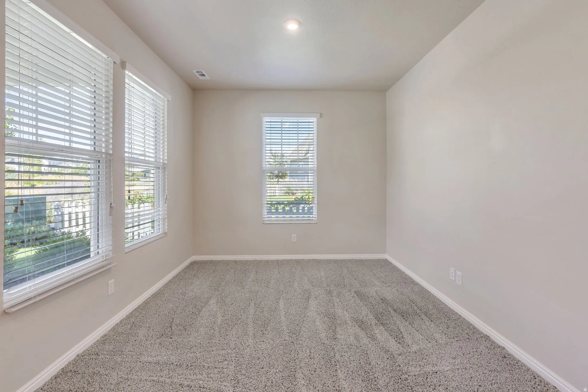 Neutral wall paint, recessed lighting, and carpet flooring
