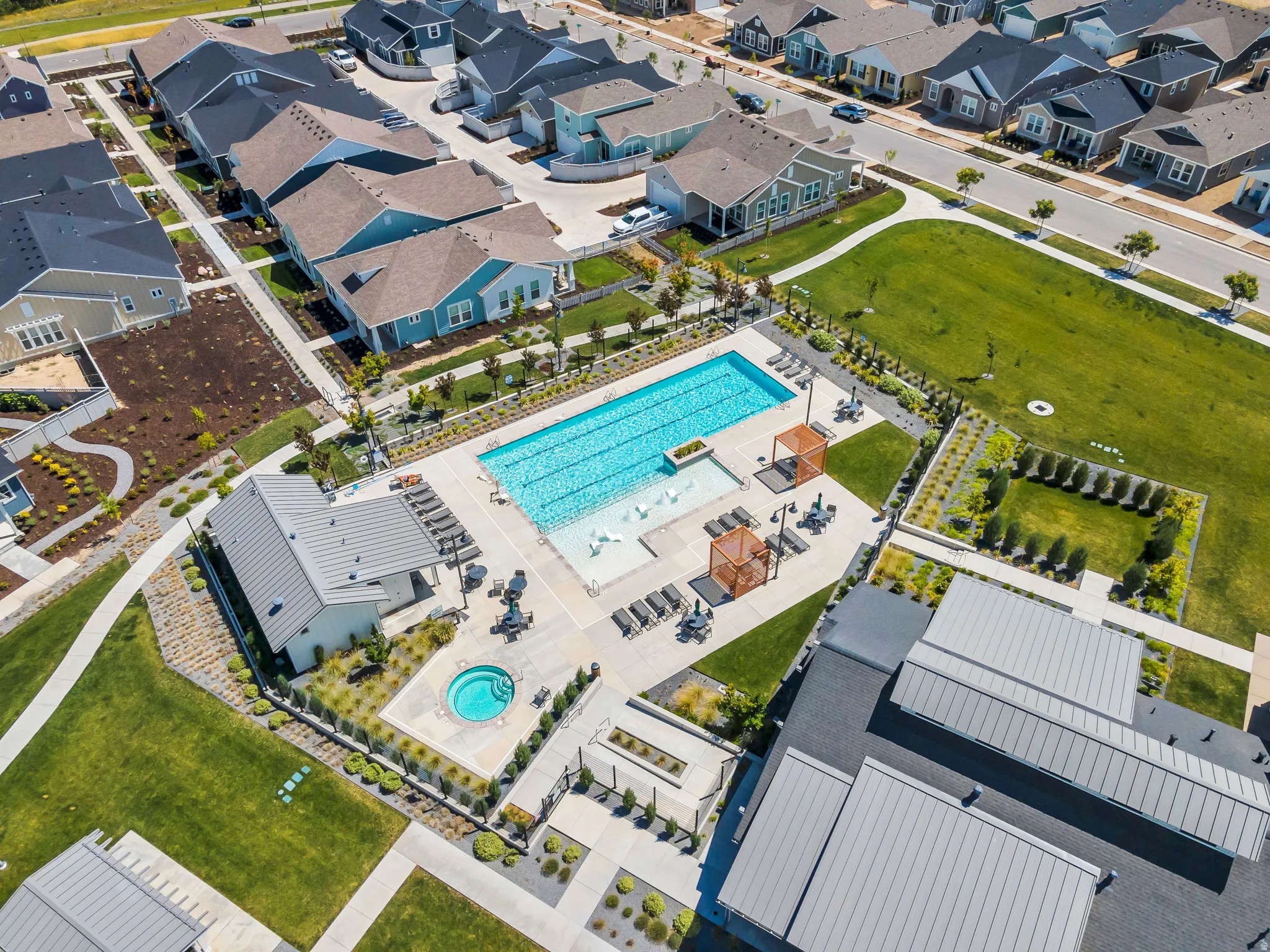 Community amenities featuring a large swimming pool, separate spa, and extensive hardscaping with lounge areas