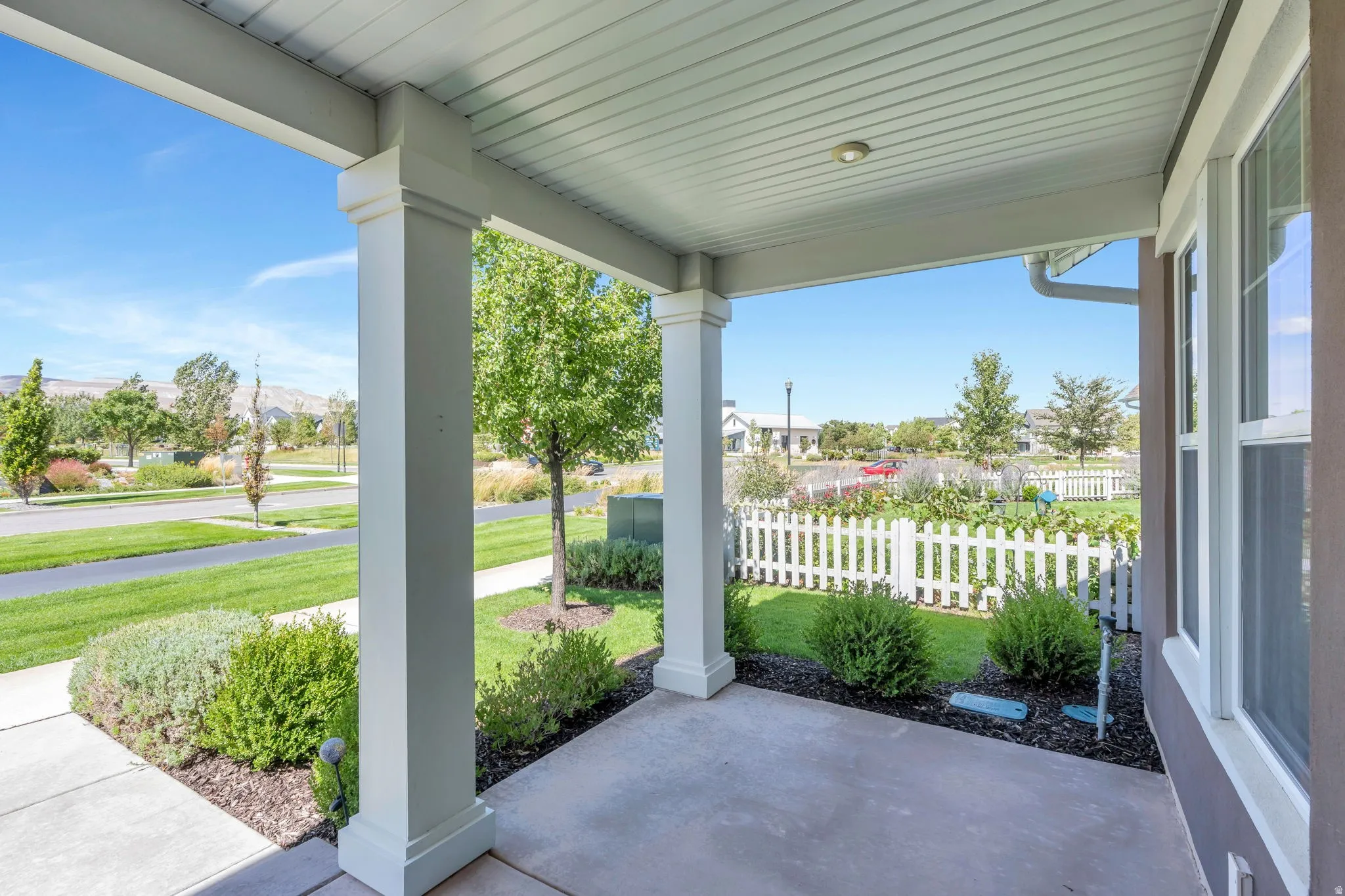 Covered front porch with concrete flooring and recessed lighting