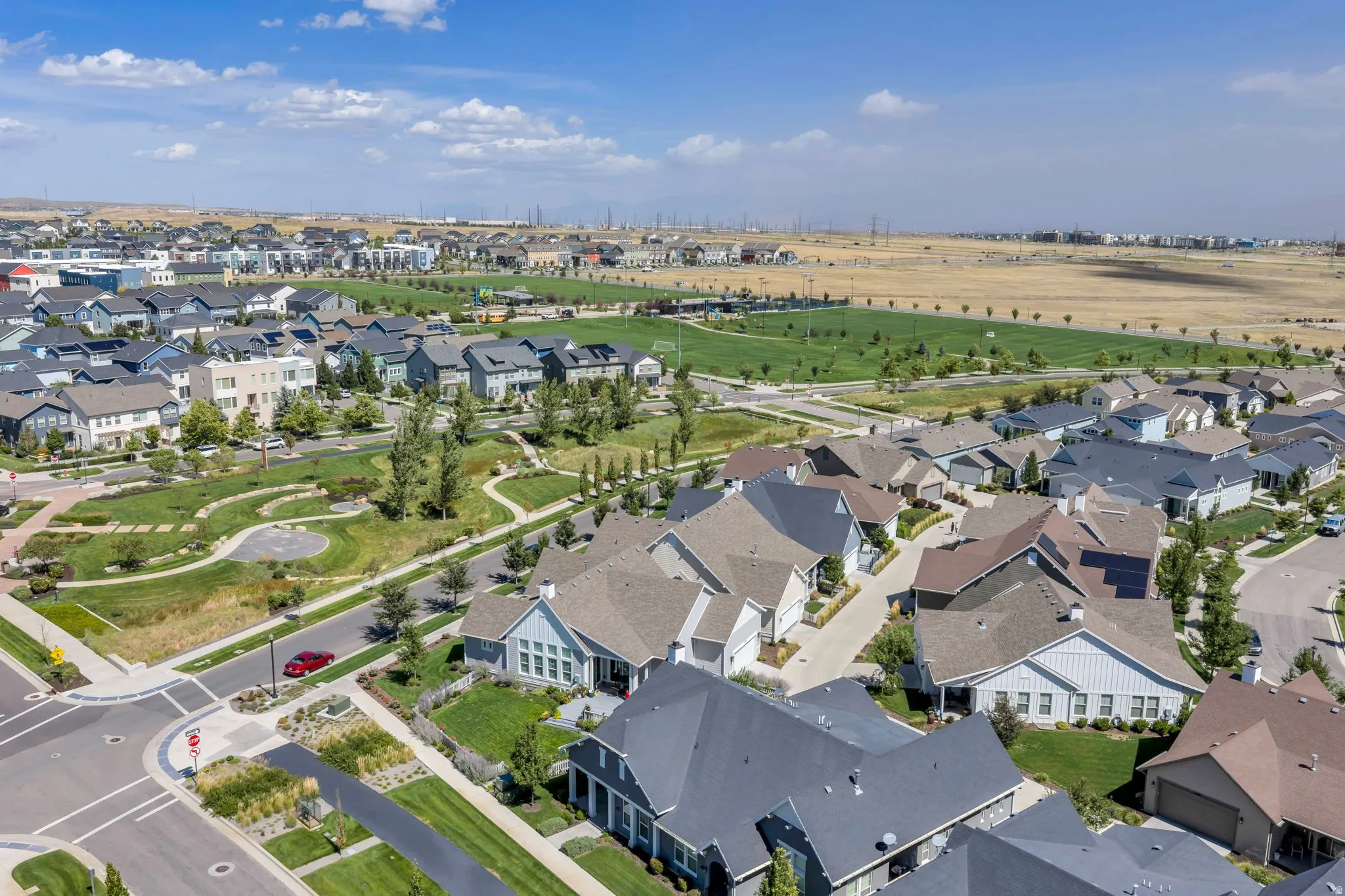 Community featuring residential architecture, green spaces, and a large recreational field