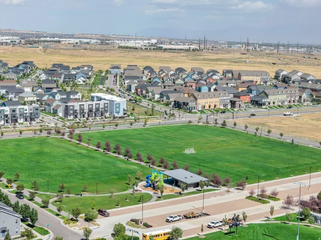 Extensive green space with a playing field, children's play structure, and covered seating area