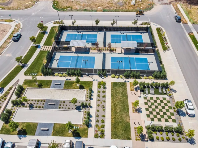 Four outdoor pickleball courts, two bocce ball courts, a checkerboard lawn, and a seating area with lounge chairs