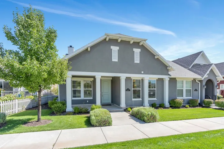 Sleek stucco exterior with prominent white trim, featuring a covered entry with columns, and a light-colored front door
