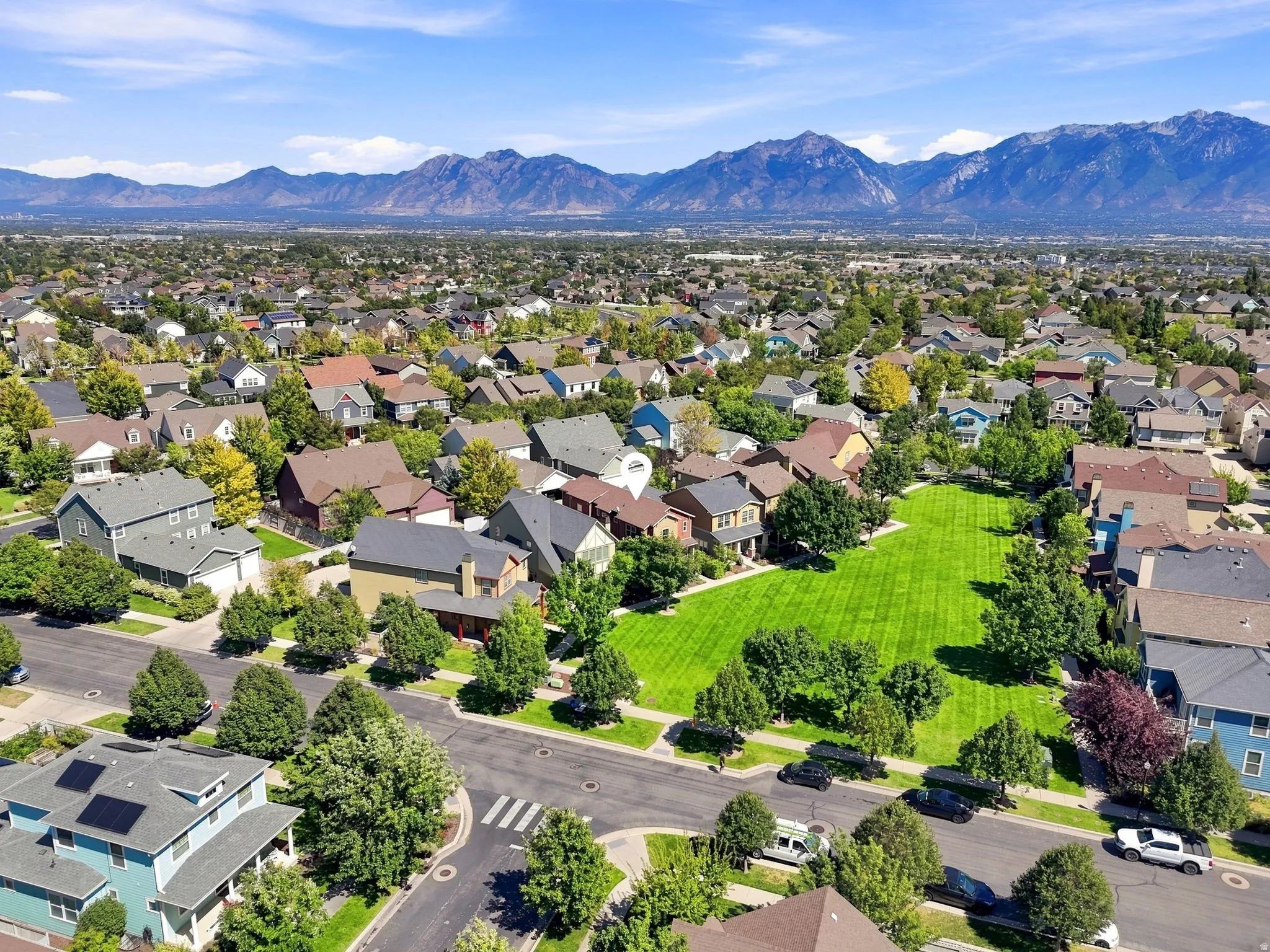Expansive neighborhood featuring residential homes, lush green spaces, and mountain backdrops