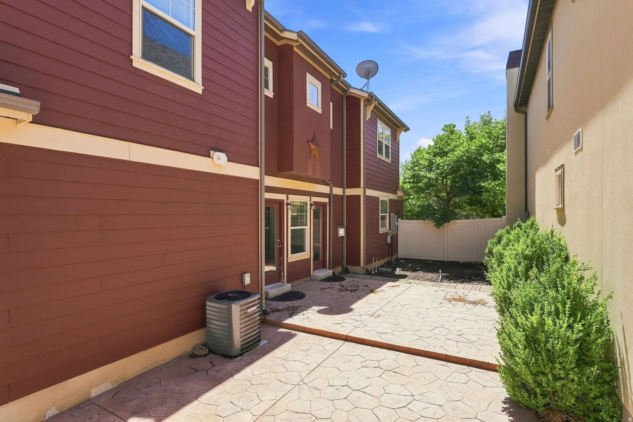 Stamped concrete patio with brown siding and beige trim