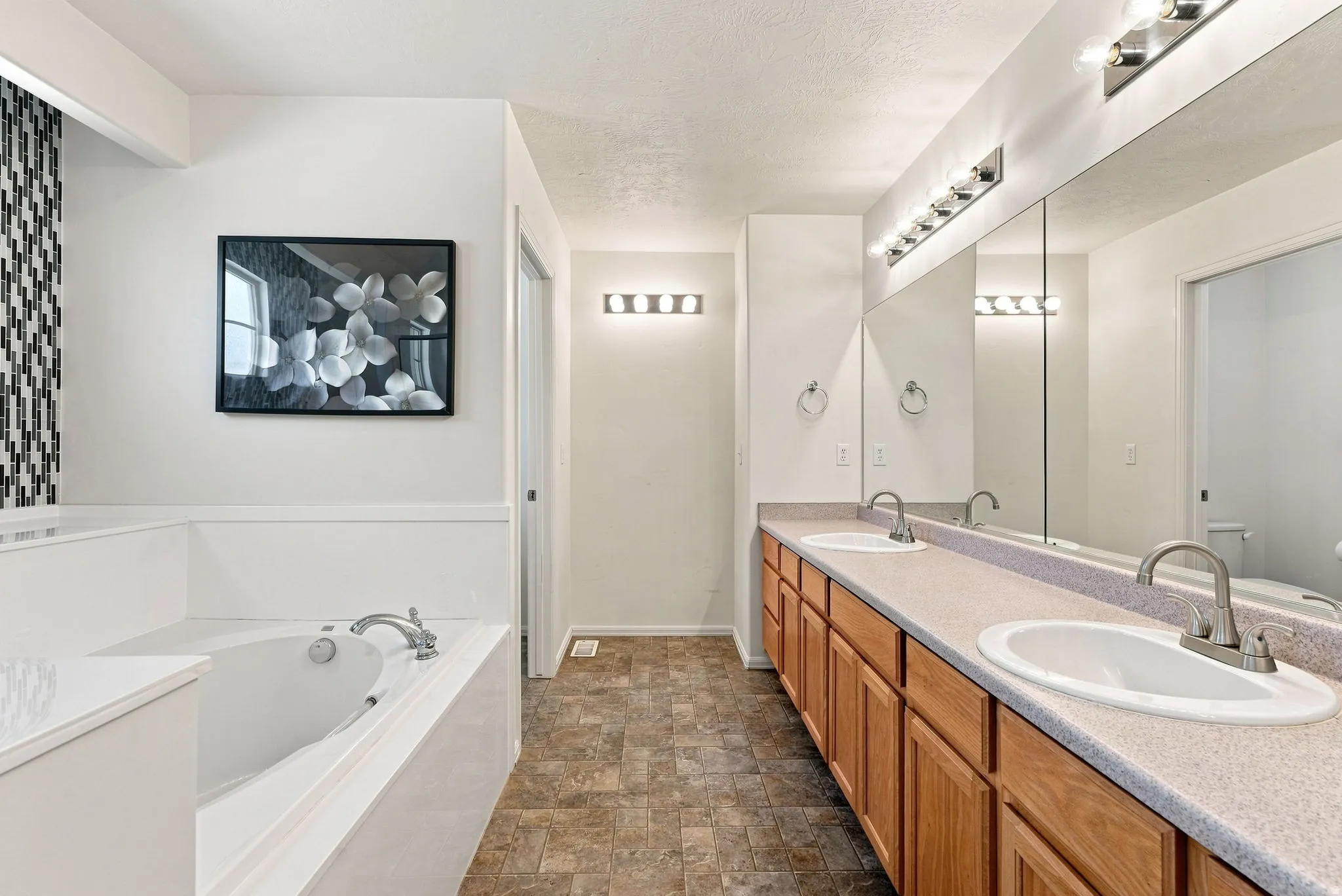 Dual vanity with integrated sinks, full-width mirror, and two contemporary light fixtures