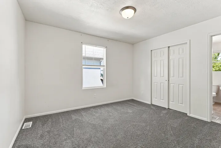 Neutral gray carpeting and white painted walls