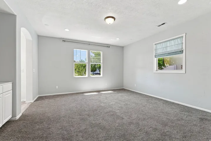 Recessed lighting, plush carpeting, arched doorway, and white cabinetry