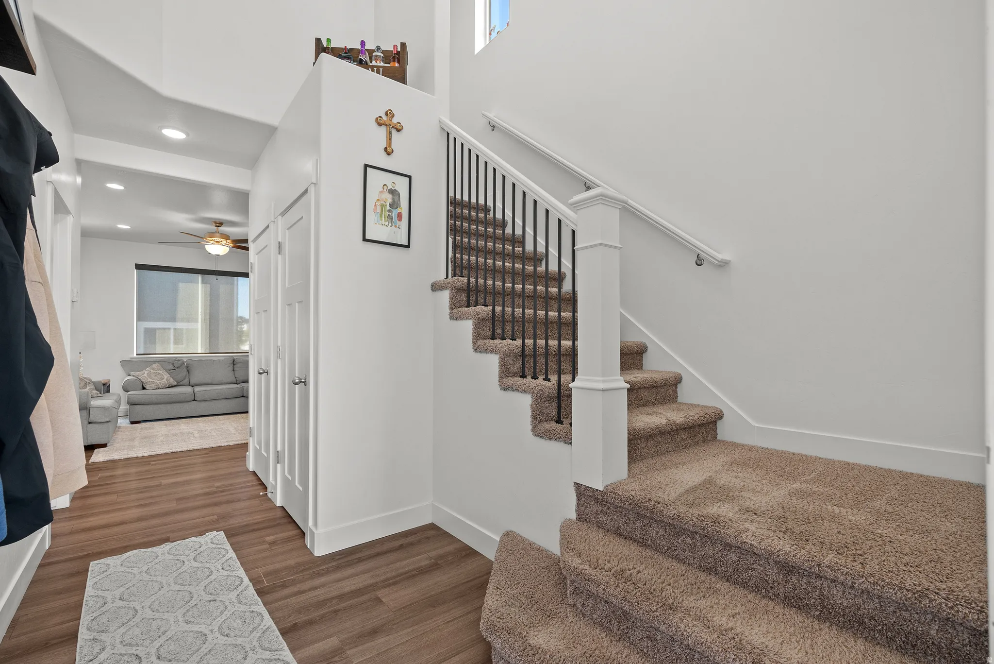 Staircase with carpeted treads and wrought iron balusters