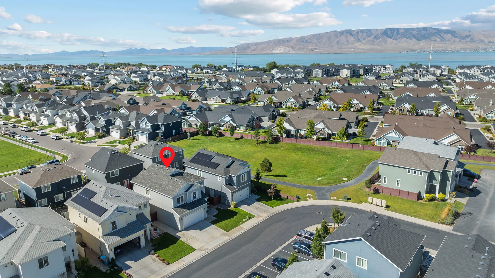 Aerial perspective of a developed residential area with a prominent body of water and mountains in the background